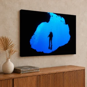 Large diver silhouette in Palau's Blue Hole canvas print on a loft wall above a teak media console